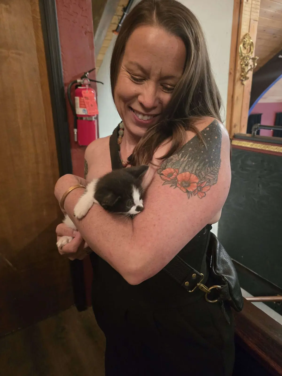 A guest holding a tuxedo kitten available for adoption at the gala